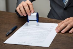 A man stamps a certificate for a business